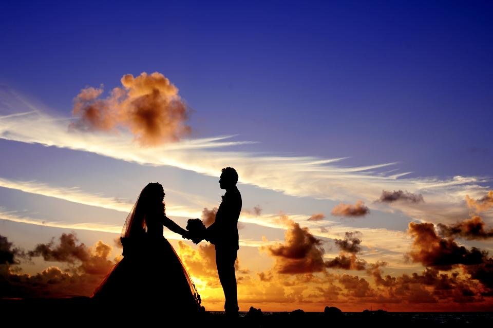 A couple walking a tropical shoreline at golden hour