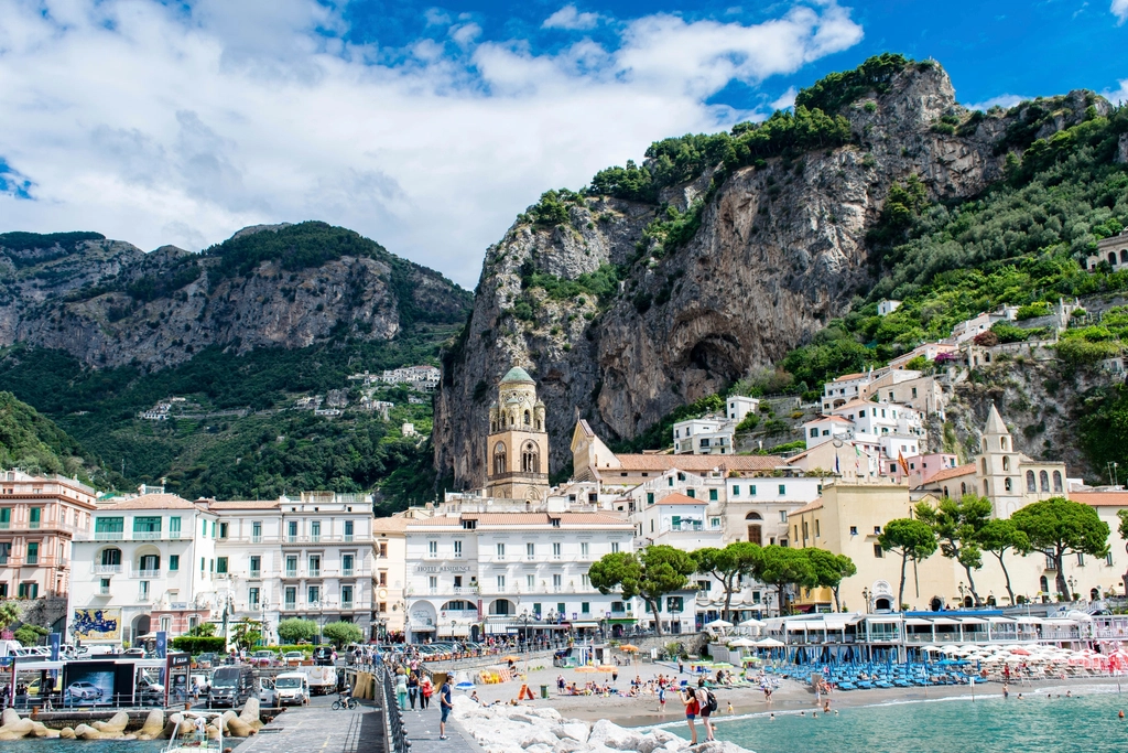 Pastel buildings stacked against cliffs above a harbour on the Amalfi Coast