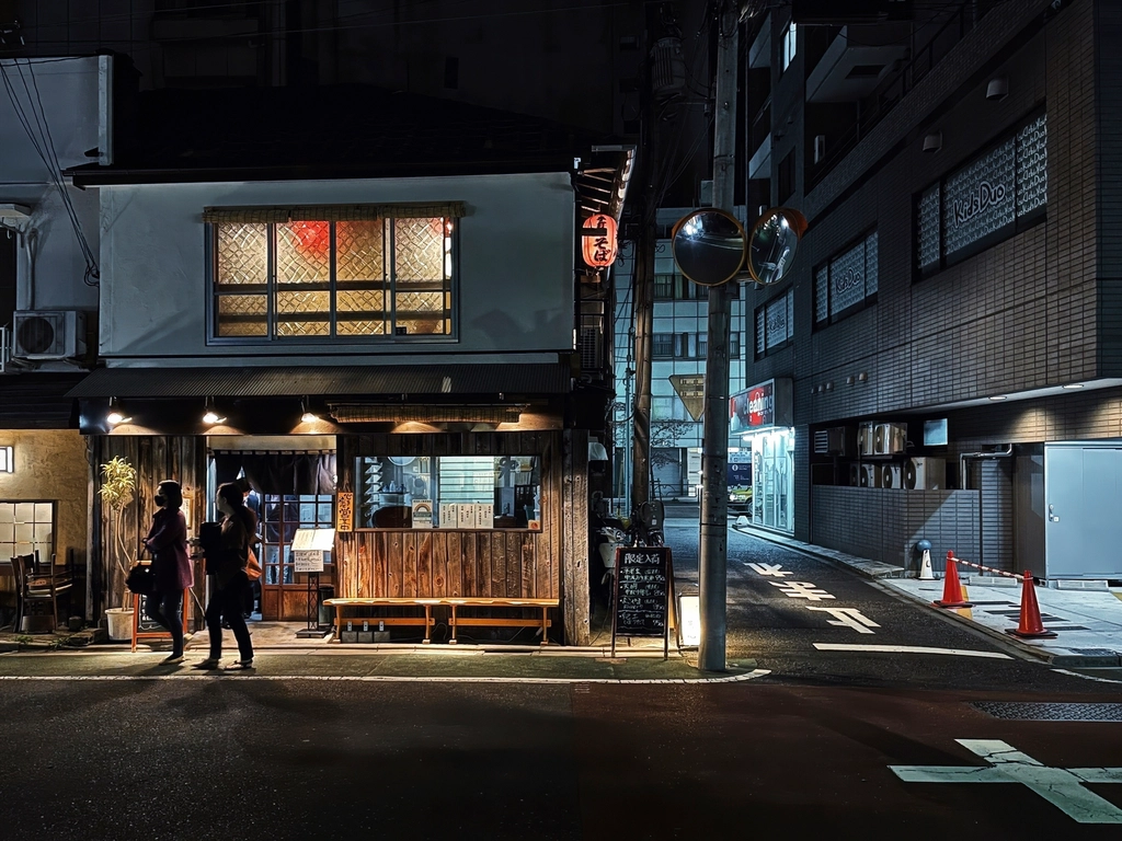 A Tokyo street lit by signs after dark